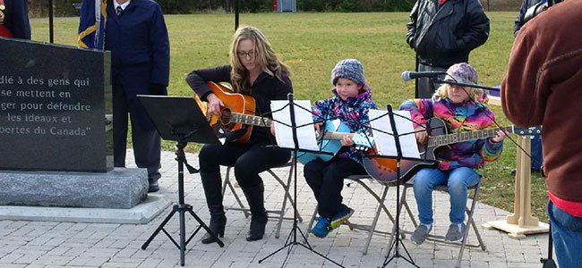 t and s playing guitars at remembrance day ceremonies at cemetary