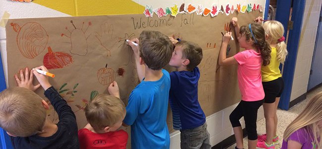 primary students making banner for fall